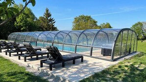 A covered outdoor seating area with lounge chairs and a pool. - La Millière - "Marie-Anne & Marie-Adélaïde & Charette" - Chambres indépendantes - Piscine & campagne - (Le Poiré-sur-Vie)