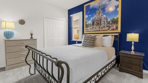 A bedroom with a bed, a dresser, a nightstand, and a wall painting. - EV_416 - 4 Bed 3 Bath with Screened-In Private Pool, Games Room (Davenport)