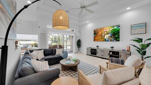 Un salon moderne comprenant un canapé, des fauteuils, une table basse et un téléviseur.