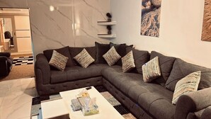 Een moderne woonkamer met een modulaire bank, een salontafel en een marmeren wand.