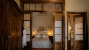 A bedroom with a bed, wooden wardrobe, and a mirror. - Hostalet dels Indians (Begur)