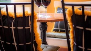A table with two wine glasses, a chalkboard with writing, and a yellow wall. - Hostalet dels Indians (Begur)