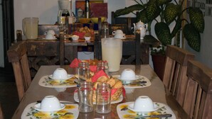 Une table à manger dressée avec plusieurs assiettes, tasses et un pichet.