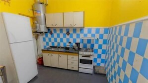 Une cuisine de taille réduite, avec des meubles blancs, une cuisinière et un évier.