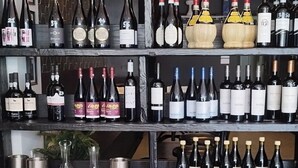 Una botellera con varias botellas y copas.