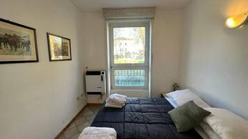 Et lille, rent værelse med seng, et vindue og en radiator.