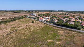 Vista aérea de un pueblo pequeño con casas, una calle principal y campos circundantes.