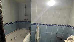 A bathroom with a bathtub, toilet, and shower.