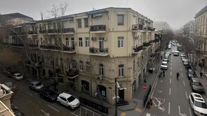 A multi-story building with a classic architectural style, featuring balconies and a central courtyard.
