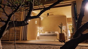 Un dormitorio con cama, mesitas de noche y ventilador de techo.