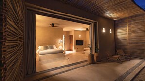 Un dormitorio moderno con cama, mesitas de noche y televisor.