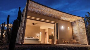 Una casa moderna con un amplio ventanal que da a una sala de estar con sofá y sillones.