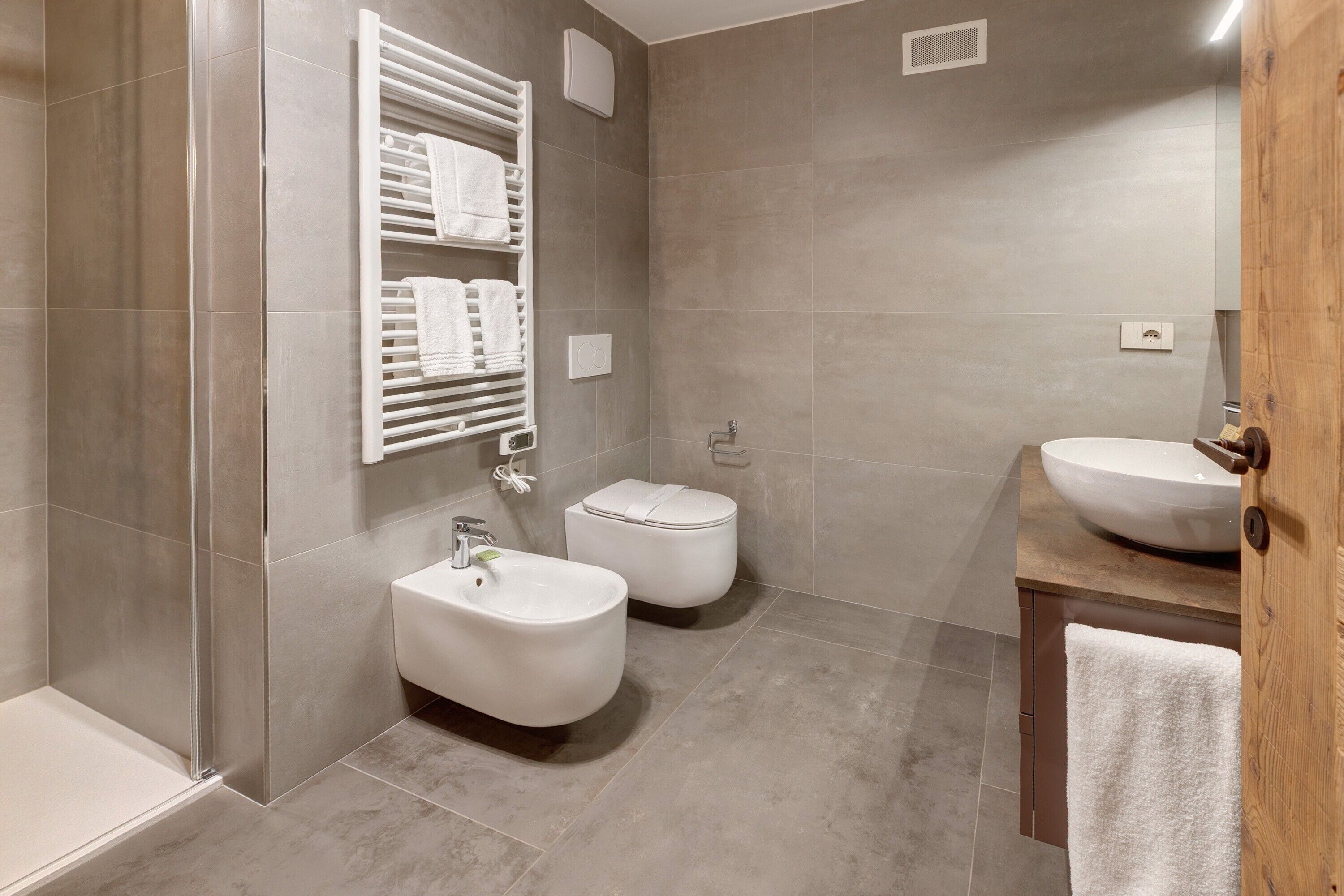 Ein modernes Badezimmer mit Dusche, Bidet, Toilette und Waschbecken.
