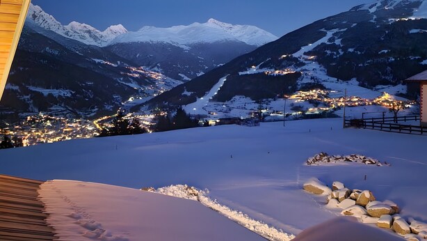 A snowy mountain landscape with a view of a town below. - Apartment 'Scoiattolo' with Mountain View, Shared Garden and Wi-Fi (Oga)