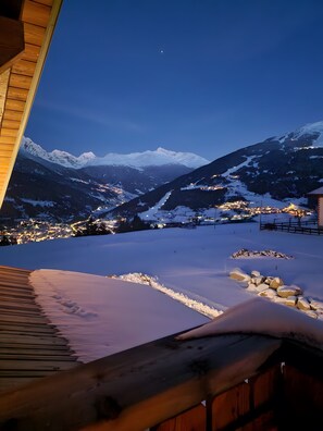 A snowy mountain landscape with a view of a town below.
