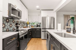 A modern kitchen with a microwave, stove, oven, and refrigerator. - Pool, Firepit, Mins to DT, SXSW, ACL, Sleeps 6 (Austin)