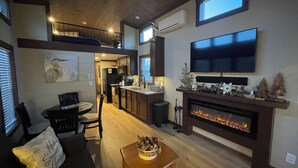 Una sala moderna con chimenea, televisor y comedor.