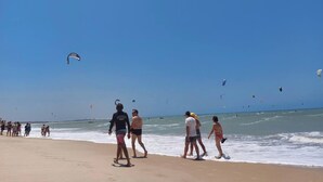 A beach with people walking and kites flying. - Cumbuco - Beach house with pool and deck Ceará (Praia de Cumbuco Caucaia)