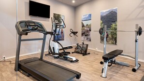 A gym with a treadmill, elliptical, stationary bike, and weight bench. - Room 'Seaberhof 6' with Lake View, Shared Pool and Wi-Fi (Caldaro)