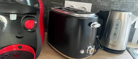 A kitchen with a Bosch mixer, a Cobalt toaster, and a black appliance with a paper towel holder.