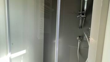 Regadera, secadora de cabello, toallas, papel de baño