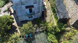 Vue aérienne d’un immeuble doté de nombreux balcons, d’un petit jardin et d’un élément décoratif aquatique.