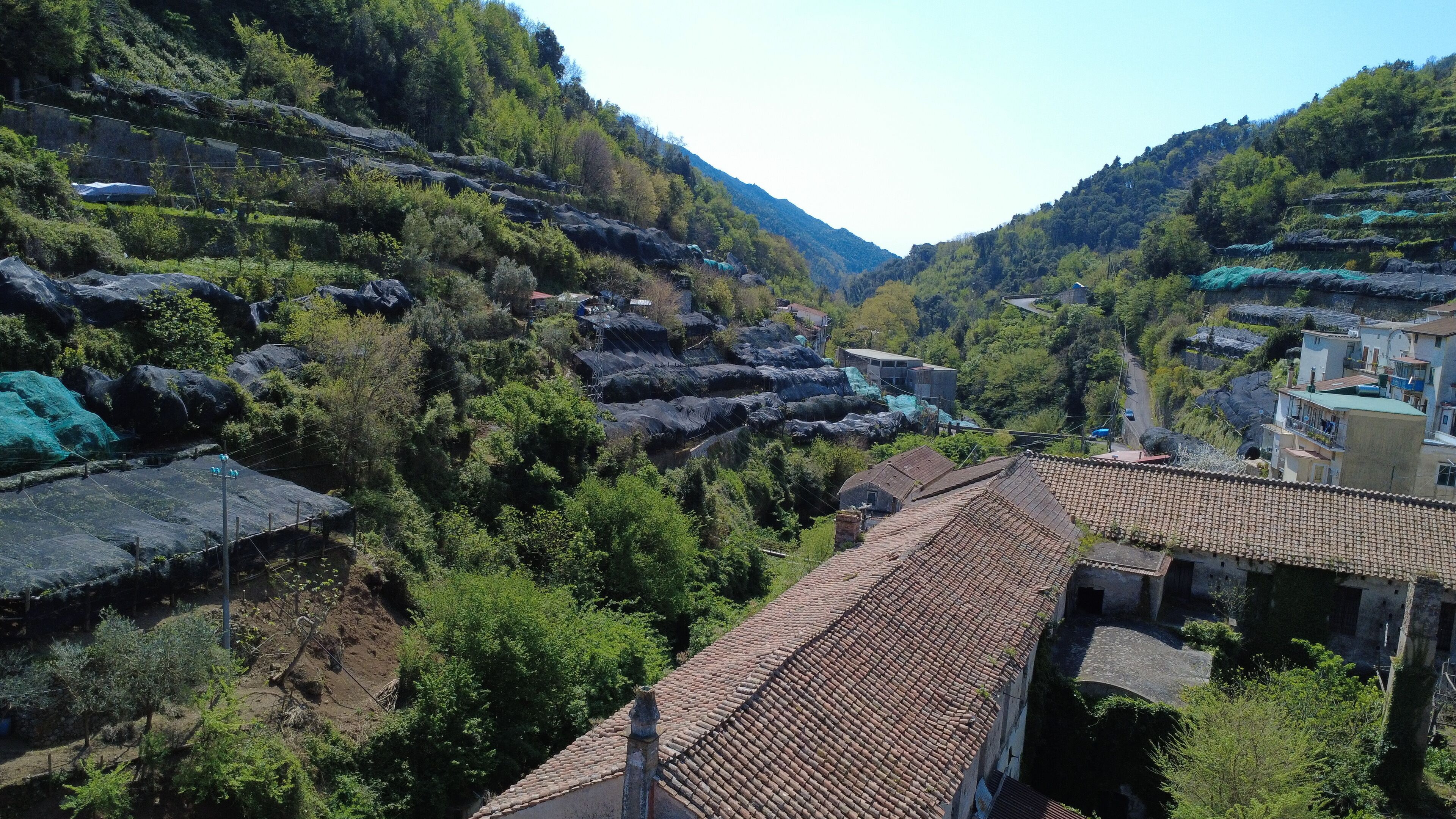 A terraced hillside village with traditional architecture, including buildings with tiled roofs and stone walls.