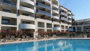 A multi-story hotel with a pool area.
