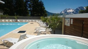 A pool area with lounge chairs and a hot tub, surrounded by mountains. - 70m from ski slopes, fitness, swimming pool, sauna, terrace, balcony, parking, tv, 25m², Chamrousse (Chamrousse)