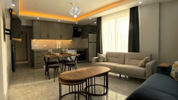Uma sala de estar moderna com sofá, mesa de centro e área de jantar com cadeiras e mesa.