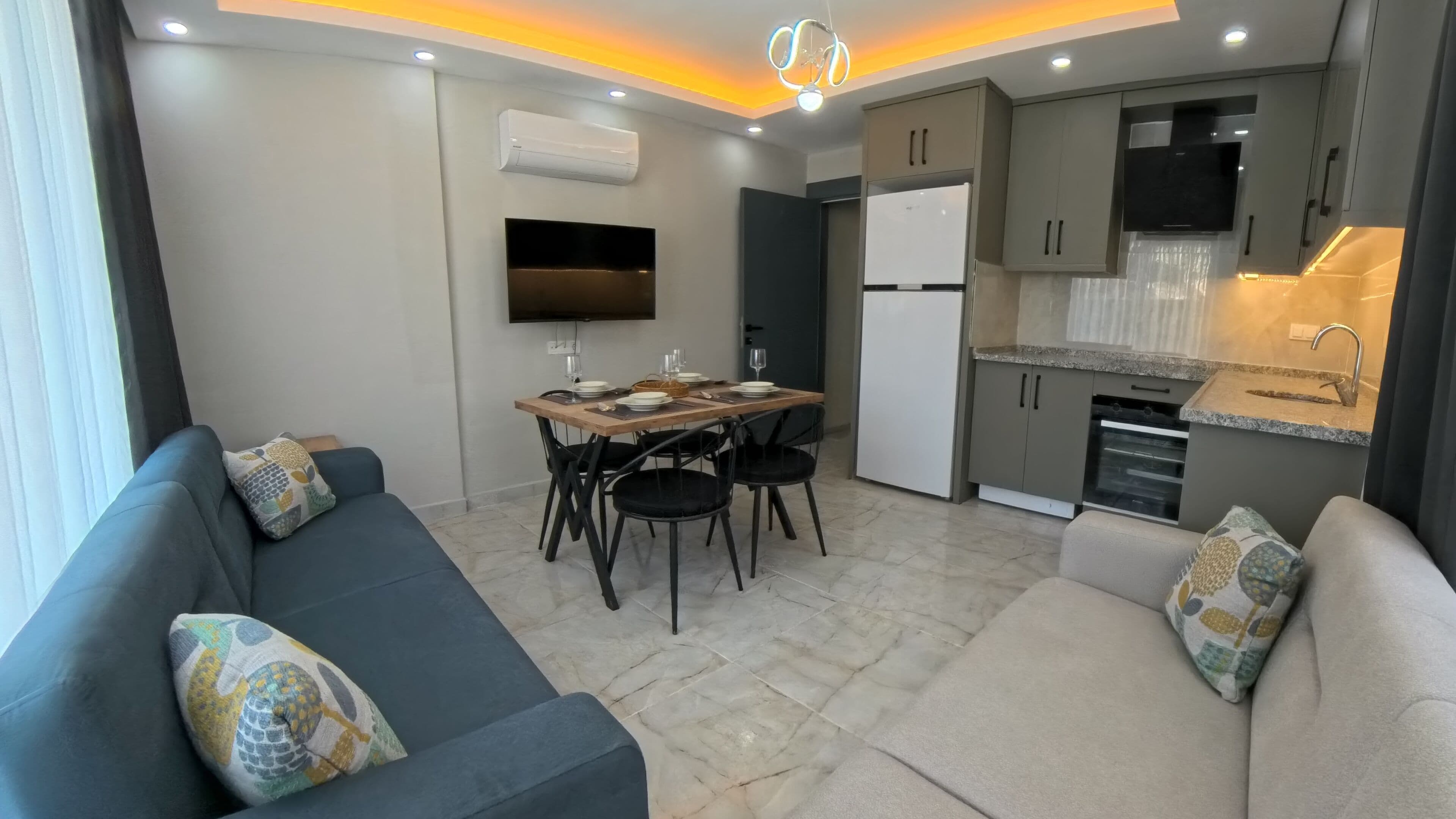 A compact living space with a sofa, dining table, and kitchenette.