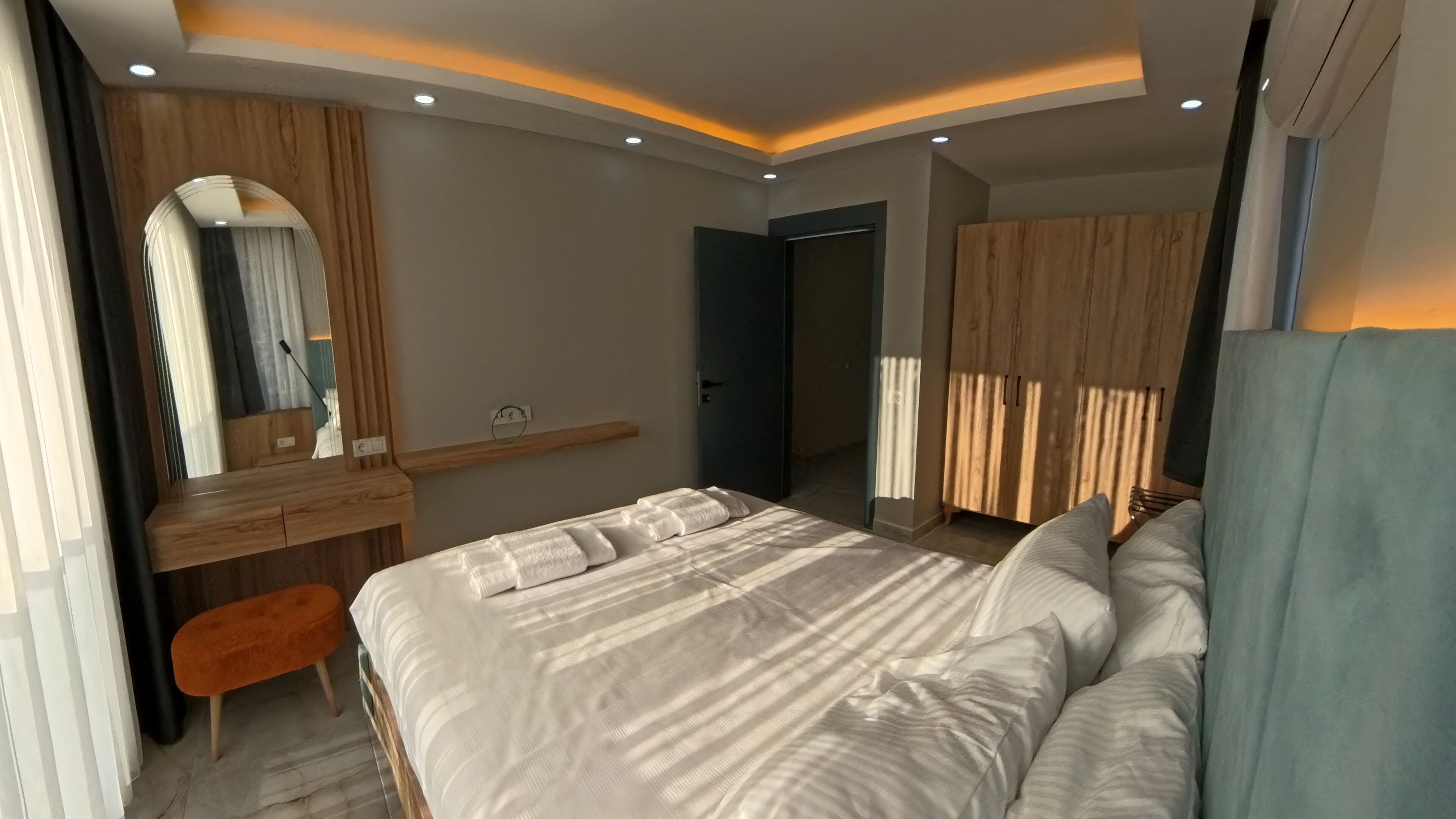 Une chambre moderne avec un grand lit, un bureau et une armoire.