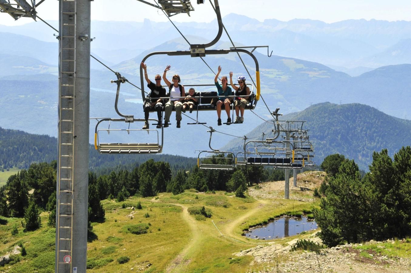 A cable car with passengers enjoying the view of a mountainous landscape.