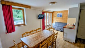 A compact room with a wooden dining table and chairs, a kitchenette with a sink, and a sofa. - 70m from ski slopes, fitness, swimming pool, sauna, balcony, parking, tv, 50-53m², Chamrousse (Chamrousse)