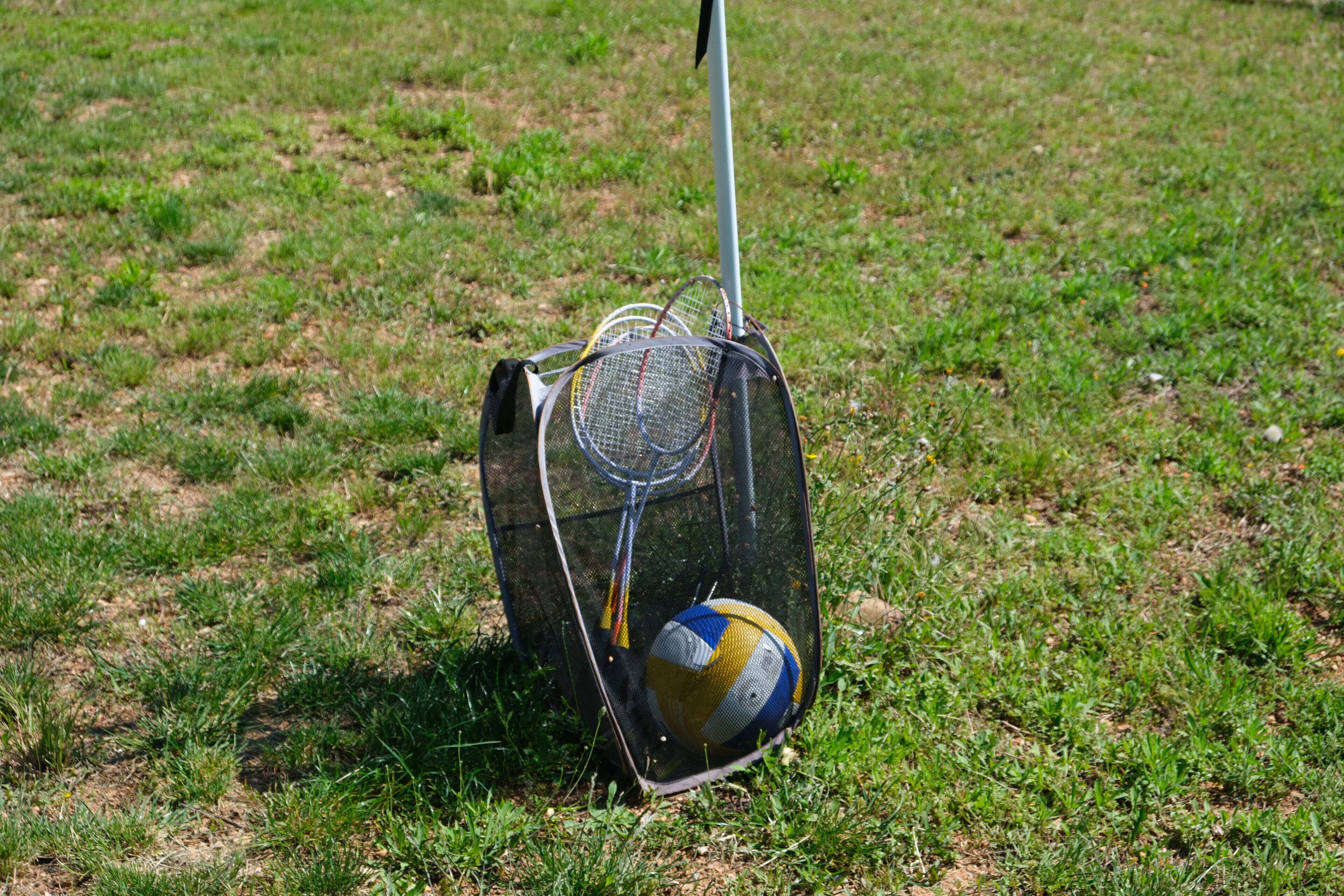 Una pelota deportiva en una red protectora sobre un campo de césped.