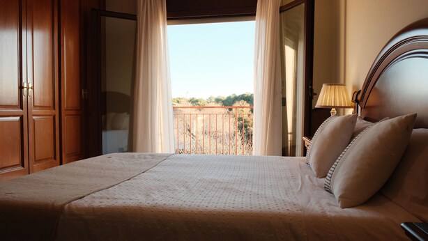 A bedroom with a bed, curtains, a nightstand, and a view of the outdoors. - L' Ametller - House Alt Empordà / Costa Brava, barbecue, volleyball (Ordis)