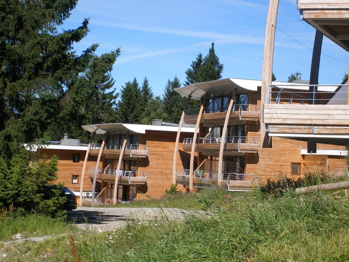 A modern building with multiple balconies and a wooden facade.