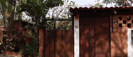 A gated entrance with a brick wall and a metal gate.