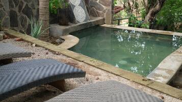 Una piscina al aire libre, sillones reclinables de piscina