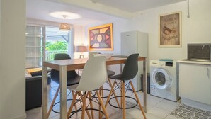 Une cuisine compacte comprenant un coin repas, un lave-linge et un réfrigérateur.