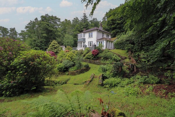 Een ruime, twee verdiepingen tellende woning, omgeven door weelderig groen en een verzorgde tuin.