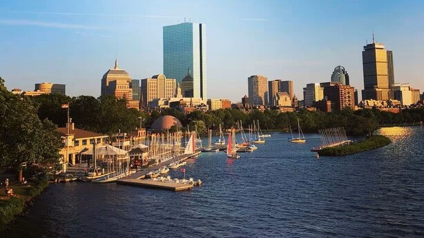 A city skyline with modern buildings, a marina with boats, and a clear blue sky. - Dazzling Oceanview-4 Train Stop Logan Airport (Revere)