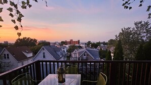A deck with a glass-top table and chairs, surrounded by a wooden railing. - Dazzling Oceanview-4 Train Stop Logan Airport (Revere)