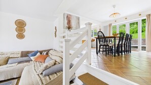 Un salon moderne comprenant un canapé, un coin repas et un escalier.