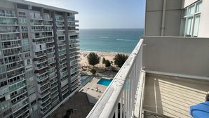 A high-rise building with multiple balconies overlooking a beach and a swimming pool. - CB171- Beautiful Ocean View With One Bedroom (Carolina)