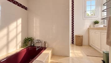 A bathroom with a bathtub, a shower, a sink, and a window.