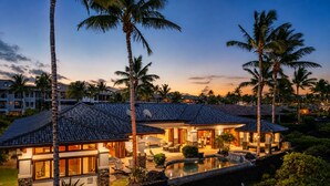 Un resort con varias villas, una piscina y palmeras.