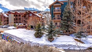 A lodge with multiple wooden buildings, a snow-covered landscape, and a clear sky. - Town Pointe Collection by KBM - 2 Units (102c/301c) (Park City)