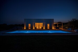 A modern house with a swimming pool, outdoor seating, and illuminated entryways. - Sky Dream Oasi Vendicari Noto (Noto)