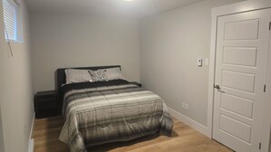Ein Schlafzimmer mit Bett, Tür und Deckenleuchte.